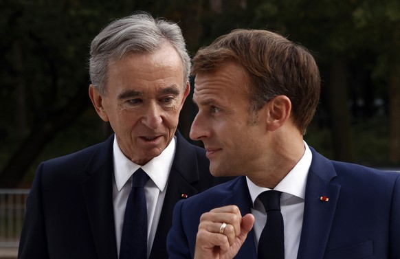 FILE - LVMH luxury group CEO Bernard Arnault, left, and French President Emmanuel Macron arrive at Fondation Louis Vuitton to visit the exhibition &#039;The Morozov Collection, Icons of Modern Art&#03 ...