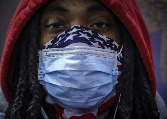 In this April 7, 2020, photo, a subway rider wears a mask and a bandana to protect himself against COVID-19 in New York. As the coronavirus tightened its grip across the country, it is cutting a parti ...