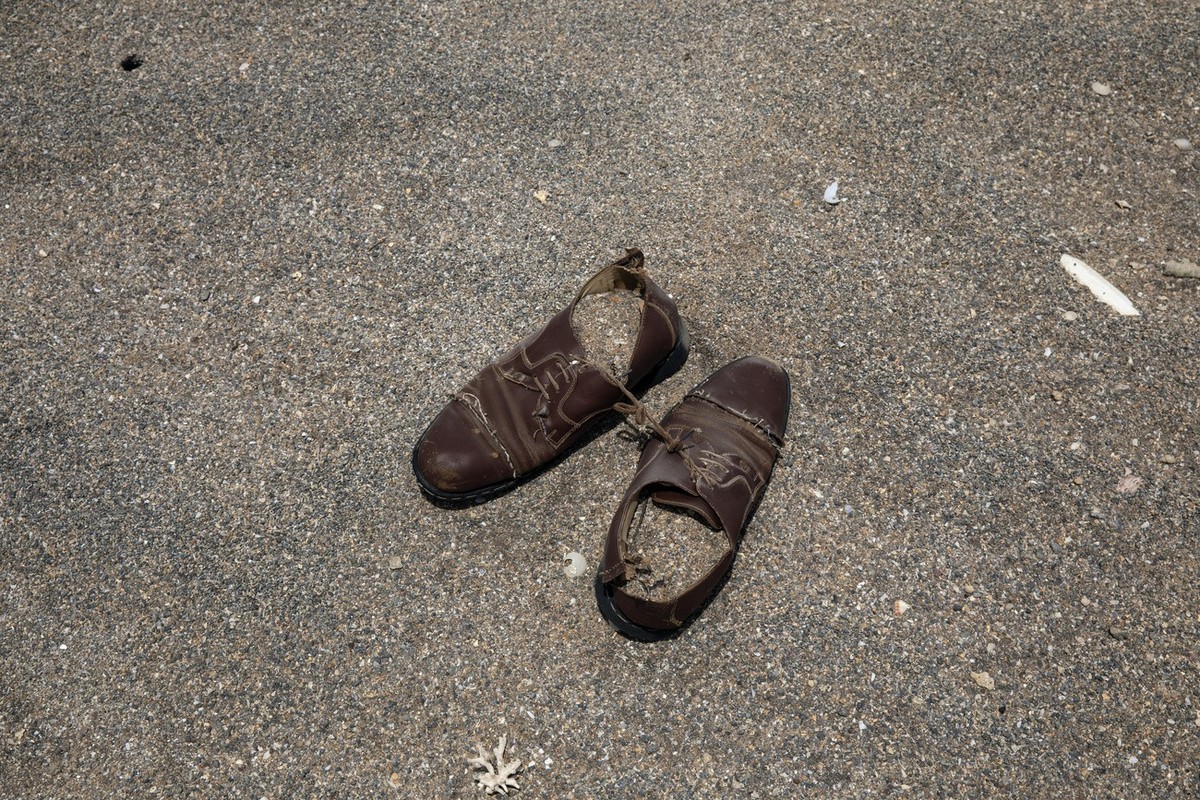 This July 15, 2019 photo, shows a pair of shoes belonging to a migrant left on the sand where African migrants gather at night to embark a boat in the uninhabited coast outside the town of Obock, the  ...
