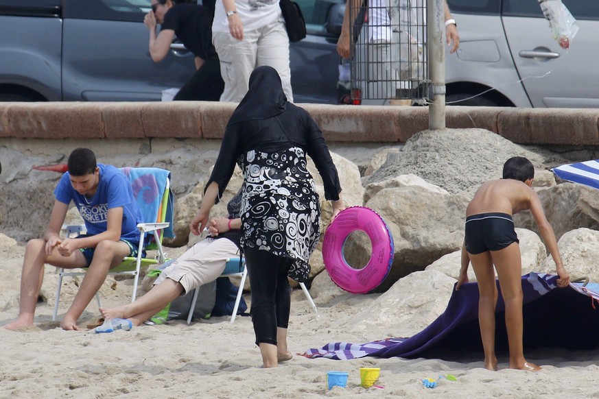 Eine Frau mit Kopfbedeckung am Strand von Marseille: In anderen Städten Frankreichs ist das Baden in Ganzkörperbekleidung verboten.&nbsp;