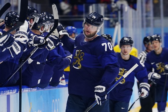 Finland&#039;s Teemu Hartikainen (70) slaps gloves with teammates after scoring a goal against Sweden during a preliminary round men&#039;s hockey game at the 2022 Winter Olympics, Sunday, Feb. 13, 20 ...