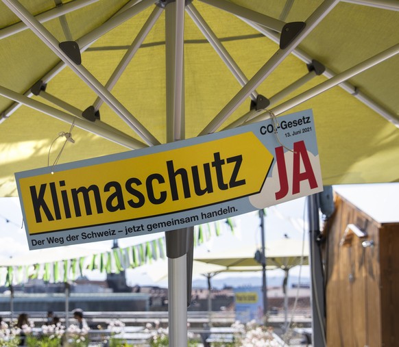Ein Plakat fuer ein Ja zum CO2-Gesetz haengt an einem Sonnenschirm, am Versammlungsort der Befuerworter des CO2-Gesetzes, am Sonntag, 13. Juni 2021, in Bern. (KEYSTONE/Peter Klaunzer)
