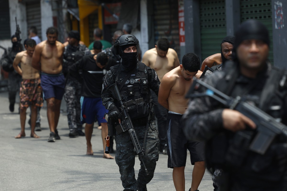 epa12487894 Rio de Janeiro Police officers guard a group of people during an operation in Rio de Janeiro, Brazil, 28 October 2025. At least twenty people were killed and fifty were arrested during a m ...
