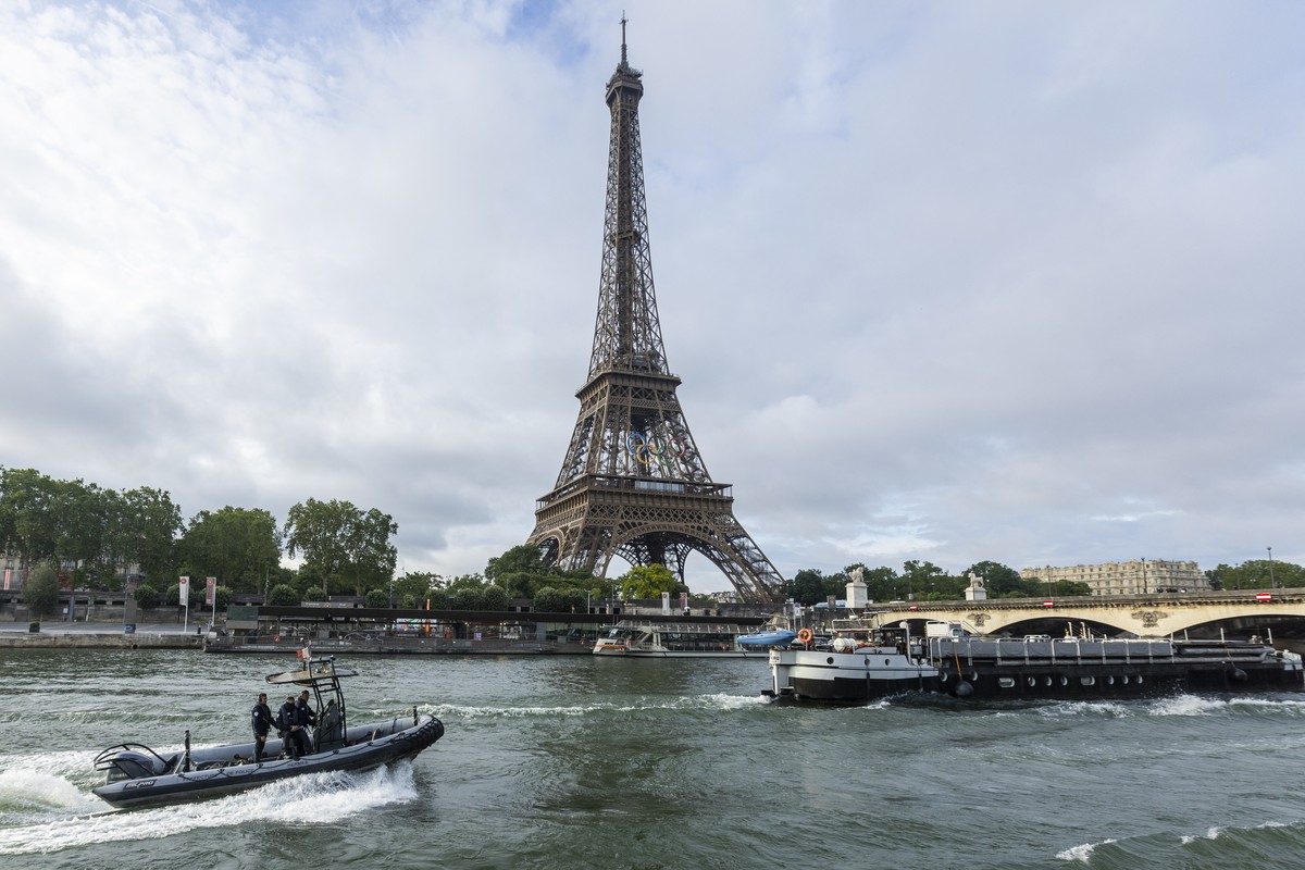 epa11417308 Sightseeing boats and a police rubber dinghy sail on the Seine river near the landmak Eiffel tower during a rehearsal for the Opening Ceremony of the 2024 Paris Olympic Games, in Paris, Fr ...