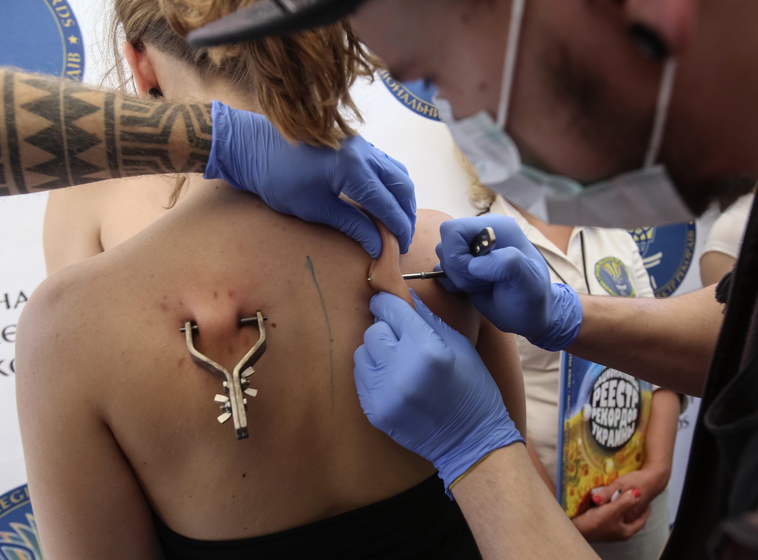 Gestatten:&nbsp;Mariya Gafitsa. Die junge Frau, Sie sehen es, lässt sich gerade einen zweiten Bolzen durch die Haut ihres Rückens schieben, ...