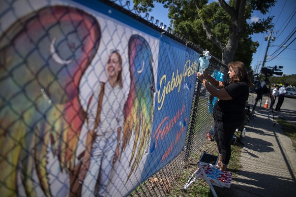 A woman places a decoration near a poster after attending the funeral service of Gabby Petito at Moloney&#039;s Funeral Home in Holbrook, N.Y. Sunday, Sept. 26, 2021. (AP Photo/Eduardo Munoz Alvarez)