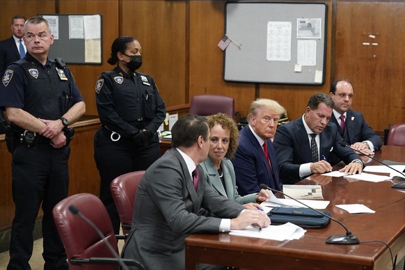 Former President Donald Trump sits with his defense team at the defense table in a Manhattan courthouse Tuesday, April 4, 2023, in New York.  Trump will appear in a New York City courtroom on charges of…