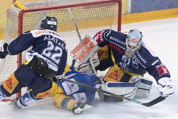 Torhueter Tobias Stephan, rechts, von Zug klaert gegen Marc Wieser, mitte, von Davos von Zug beim dritten Eishockey Playoff Halbfinalspiel der National League A zwischen dem EV Zug und dem HC Davos am ...