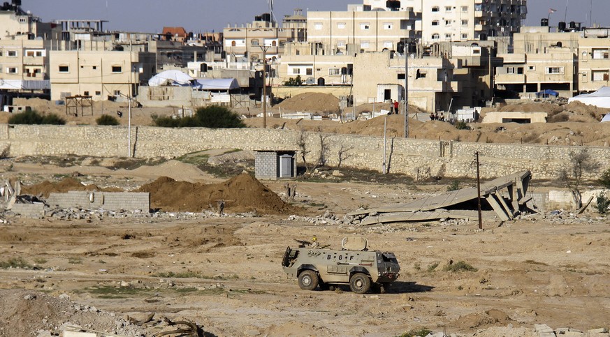 In this Thursday, Nov. 6, 2014 photo, an Egyptian army armored vehicle stands on the on the Egyptian side of border town of Rafah, northeast of Cairo, Egypt. In the deadliest-ever militant attack on t ...