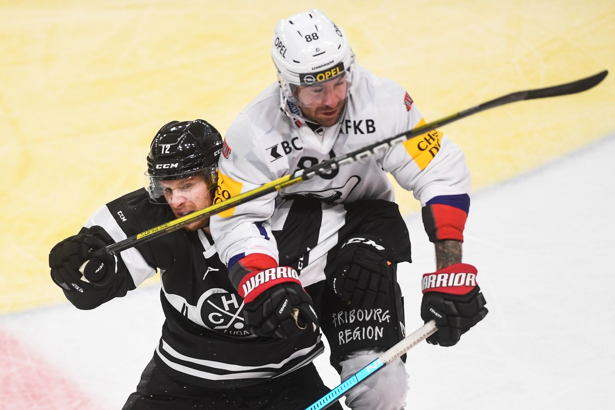 Lugano's player Dominic Lammer, left, and Fribourg's player Fribourg's player Christopher DiDomenico fight for the puck, during the friendly match of National League (NL) Swiss Champion ...