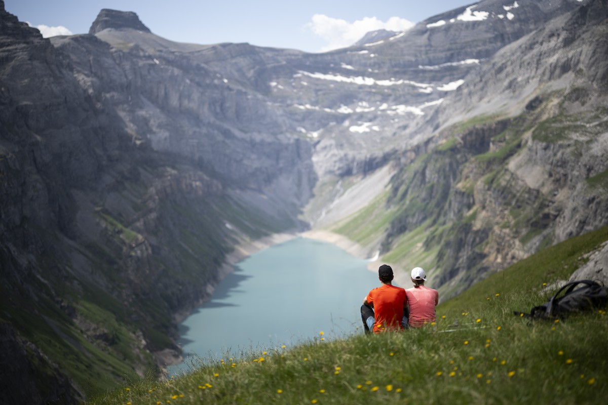 Zwei Wanderer geniessen die Aussicht auf den Limmerensee, einen Speichersee, aufgenommen am Montag, 10. Juli 2023, in Linthal. (KEYSTONE/Gian Ehrenzeller)