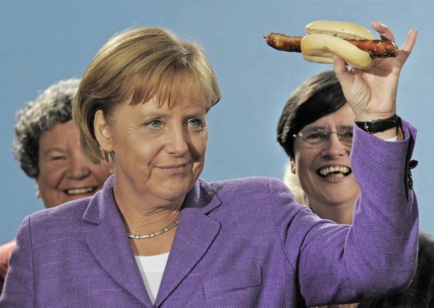 Bundeskanzlerin Angela Merkel, vorne, haelt eine Original Thueriunger Rostbratwurst am Dienstag, 15. Sept. 2009, in Erfurt, Thueringen, neben Christine Lieberknecht, Sozialministerin Thueringens, rech ...