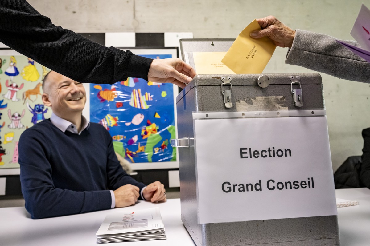 KEYPIX - Un electeur glisse son bulletin de vote pour le Grand Conseil dans l'urne de vote lors du premier tour des elections cantonales en Valais le dimanche 2 mars 2025 a Miege dans la commune  ...