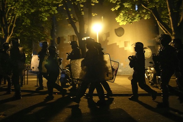 A group of police officers walk during a protest in Nanterre, outside Paris, France, Saturday, July 1, 2023. French President Emmanuel Macron on Friday urged parents to keep teenagers at home and introduce…