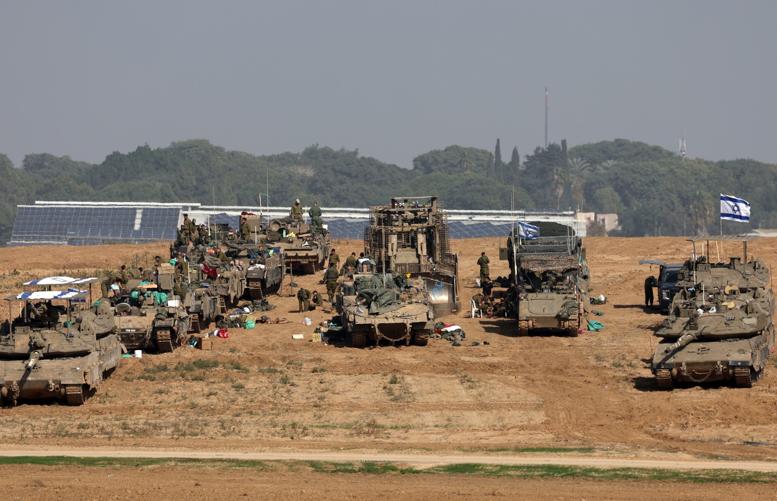 epa11007090 Israeli soldiers with their armoured fighting vehicles gather at a position near the border with the Gaza Strip, in southern Israel, 02 December 2023. The IDF announced on 02 December they ...