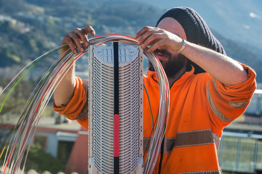 Ein Arbeiter montiert Glasfaserkabel der Swisscom fuer den Internetansschluss von Privathaushalten, am Dienstag, 10. Februar 2015 in Bellinzona. Die staedtischen Betriebe Bellinzona &quot;Aziende Muni ...