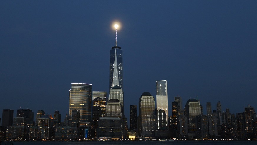 epa04166716 A near full moon rises behind the One World Trade Center in New York City as it is seen from Hoboken, New Jersey, USA, 13 April 2014. EPA/GARY HERSHORN/INSIDER IMAGES