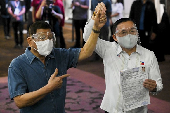 epa09501209 Philippine Senator Christopher &#039;Bong&#039; Go (R), accompanied by Philippine President Rodrigo Duterte (L), files his certificate of candidacy for vice president at a hotel used as a  ...