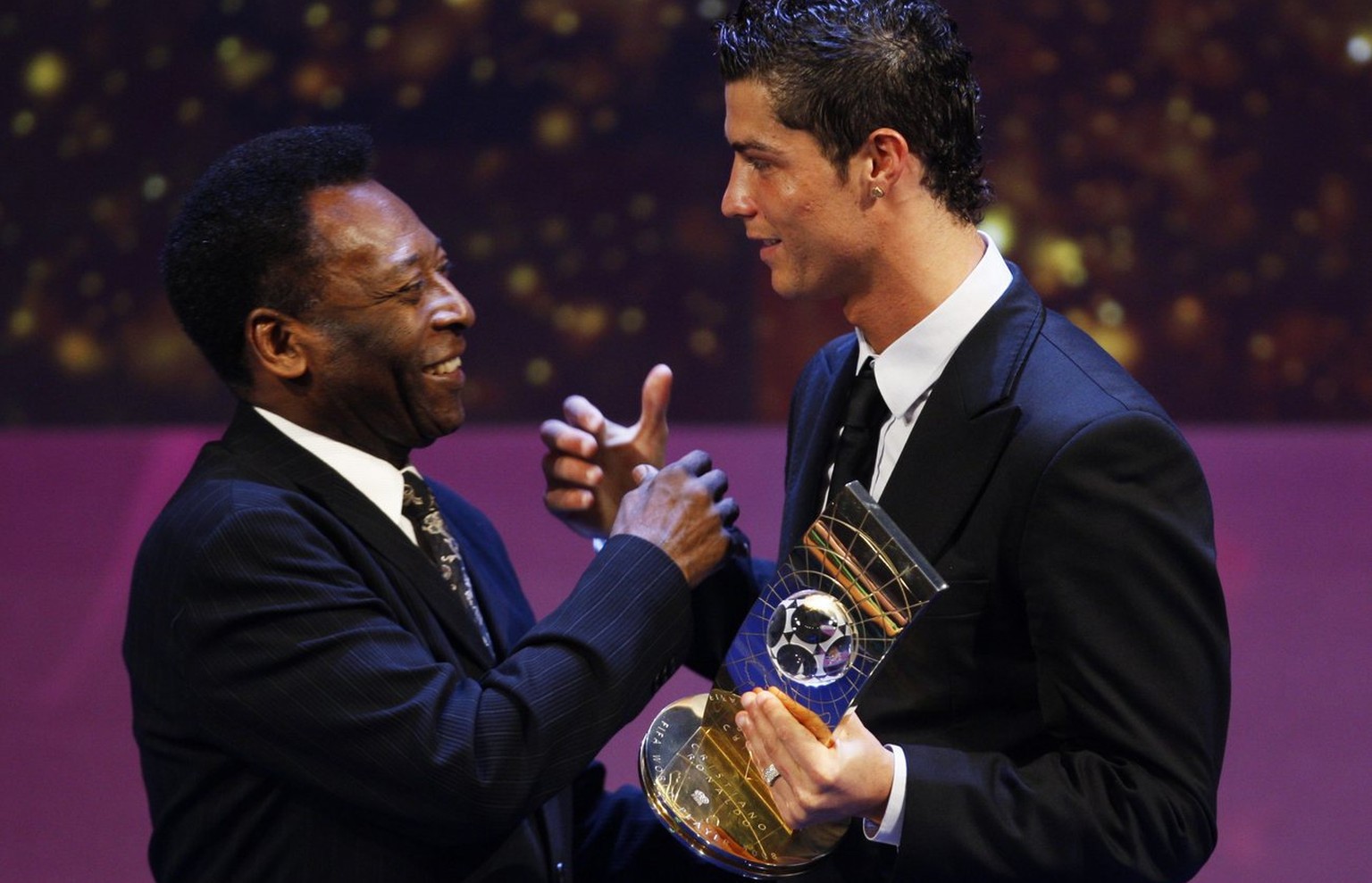 Soccer player Cristiano Ronaldo from Portugal, right, receives the trophy from former Brazilian soccer star Pele, left, after being named FIFA World Player of the Year during the FIFA World Player Gal ...