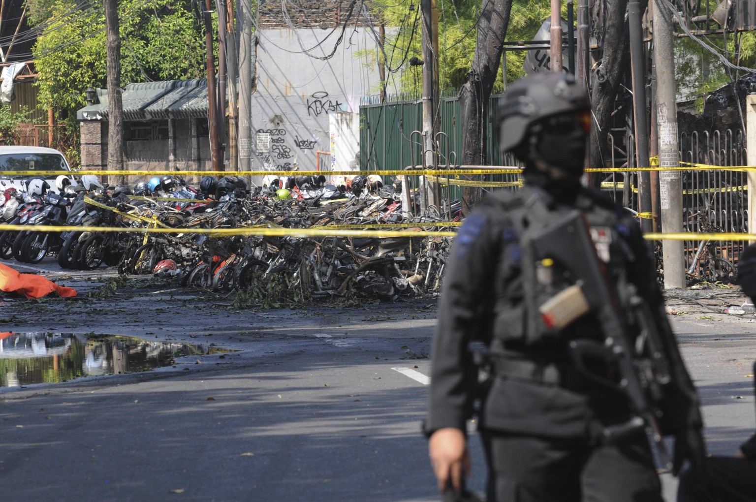 A police officer stands guard near the site where an explosion went off outside a church in Surabaya, East Java, Indonesia, Sunday, May 13, 2018. Multiple attacks including one by a suicide bomber dis ...