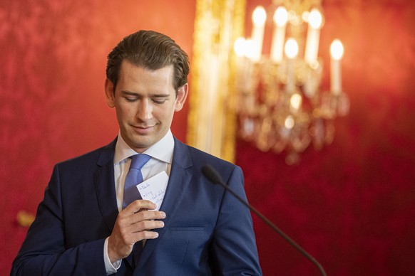 epa07583946 Austrian Chancellor Sebastian Kurz pulls his talking points during a statement with Austrian President Alexander Van der Bellen after a meeting at the Presidential office in Vienna, Austri ...