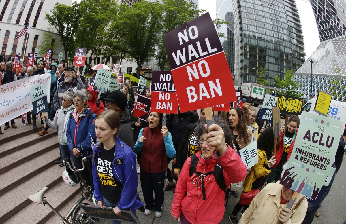 FILE - In this May 15, 2017 file photo, protesters wave signs and chant during a demonstration against President Donald Trump's revised travel ban, outside a federal courthouse in Seattle. The Su ...