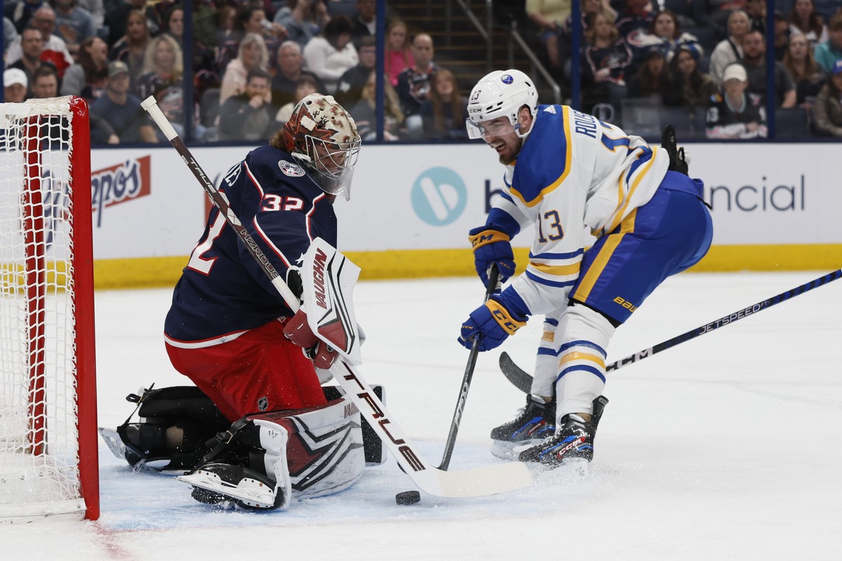 Columbus Blue Jackets' Jon Gillies, left, makes a save against Buffalo Sabres' Lukas Rousek during the first period of an NHL hockey game Friday, April 14, 2023, in Columbus, Ohio. (AP Photo ...