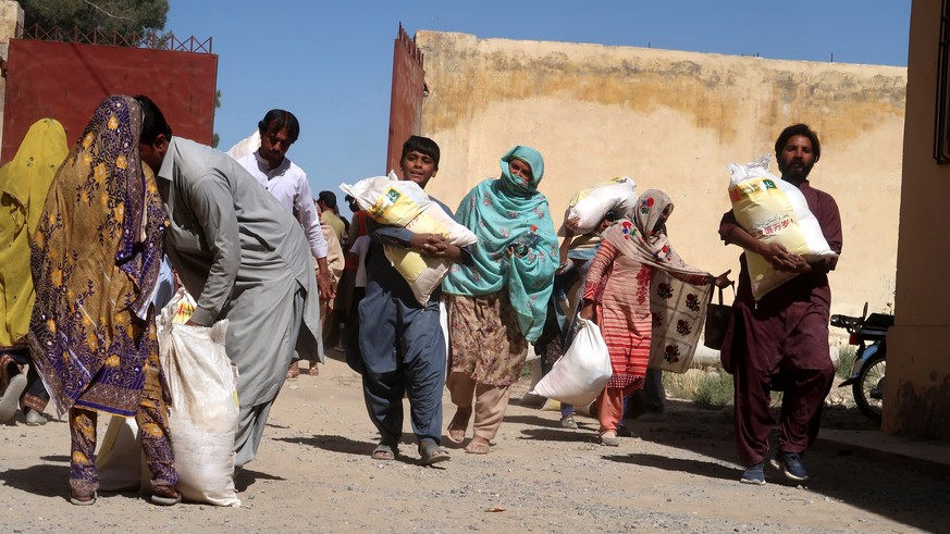 epa10267550 People affected by floods receive free ration distributed by Alkhidmat Foundation, with support of the Chinese government, in Karachi, Sindh province, Pakistan, 26 October 2022. According  ...