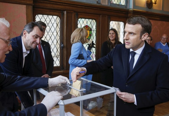 French President Emmanuel Macron casts his ballot for the first round of the mayoral elections in Le Touquet, northern France, Sunday March 15, 2020. France is holding nationwide elections Sunday to c ...