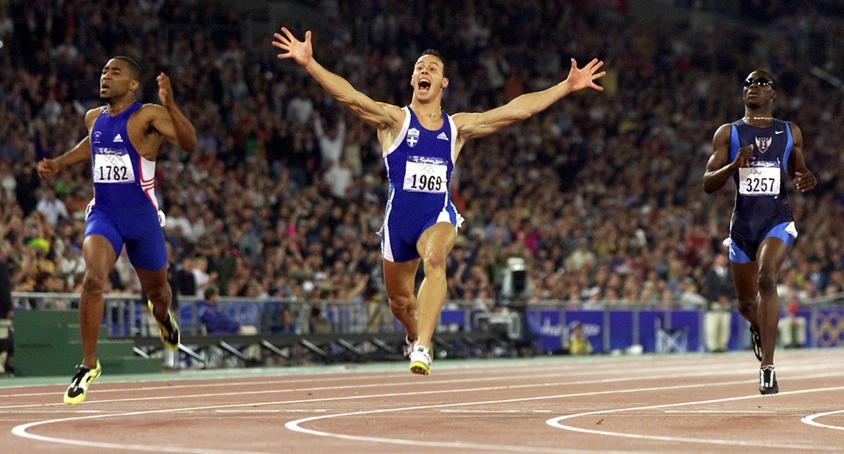 Greece's Konstantinos Kenteris, center, celebrates winning the gold medal in the men's 200 meter run at the Summer Olympics Thursday, Sept. 28, 2000, at Olympic Stadium in Sydney. At left is ...