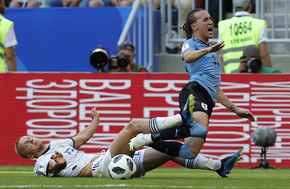 Russia&#039;s Igor Smolnikov, left, and Uruguay&#039;s Diego Laxalt challenge for the ball during the group A match between Uruguay and Russia at the 2018 soccer World Cup at the Samara Arena in Samar ...