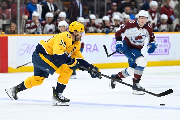 Nashville Predators defenseman Roman Josi (59) skates with the puck as Colorado Avalanche center Parker Kelly defends during the first period of an NHL hockey game Saturday, Nov. 22, 2025, in Nashvill ...