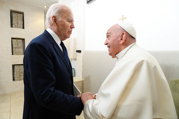 epa11411463 A handout photo made available by the Vatican Media shows Pope Francis (R) talking to US President Joe Biden (L) during a bilateral meeting on the second day of the G7 summit, in Borgo Egn ...