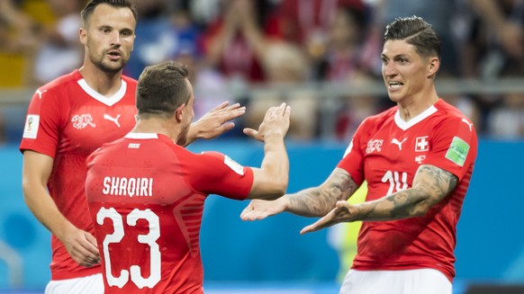 Switzerland's midfielder Steven Zuber, right, celebrates after scoring a goal with Switzerland's forward Haris Seferovic, and Switzerland's midfielder Xherdan Shaqiri, during the FIFA soccer World Cup ...