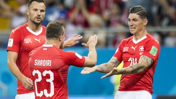 Switzerland&#039;s midfielder Steven Zuber, right, celebrates after scoring a goal with Switzerland&#039;s forward Haris Seferovic, and Switzerland&#039;s midfielder Xherdan Shaqiri, during the FIFA s ...