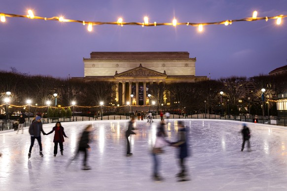 epa12595280 Visitors to the National Mall ice skate at a temporary rink in the Smithsonians sculpture garden in Washington, DC, USA, 15 December 2025. EPA/JIM LO SCALZO