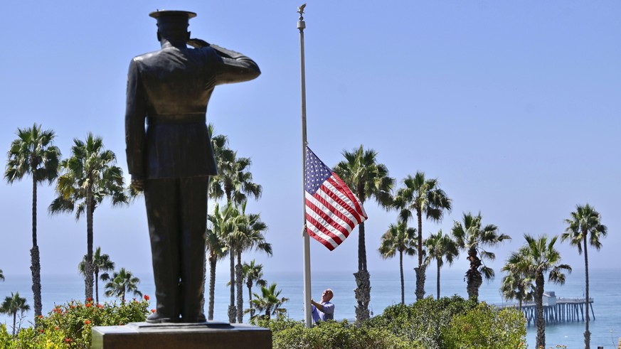 Wayne Eggleston lowers the U.S. flag to half mast at Park Semper Fi in San Clemente, Calif., Friday, Aug. 27, 2021. Eggleston is the former mayor and manages the park that sits on a bluff above the ci ...