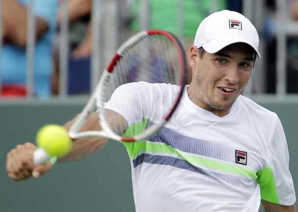 Dusan Lajovic, of Serbia, returns the ball to Alexandr Dolgopolov, of Ukraine, during the Sony Open tennis tournament, Monday, March 24, 2014, in Key Biscayne, Fla. (AP Photo/Luis M. Alvarez)