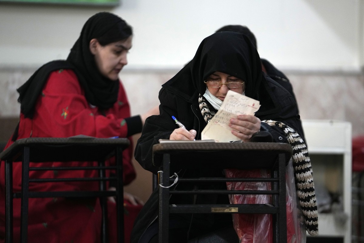 Voters fill out their ballots during the parliamentary and Assembly of Experts elections at a polling station in Tehran, Iran, Friday, March 1, 2024. Iran held the country's first election since  ...