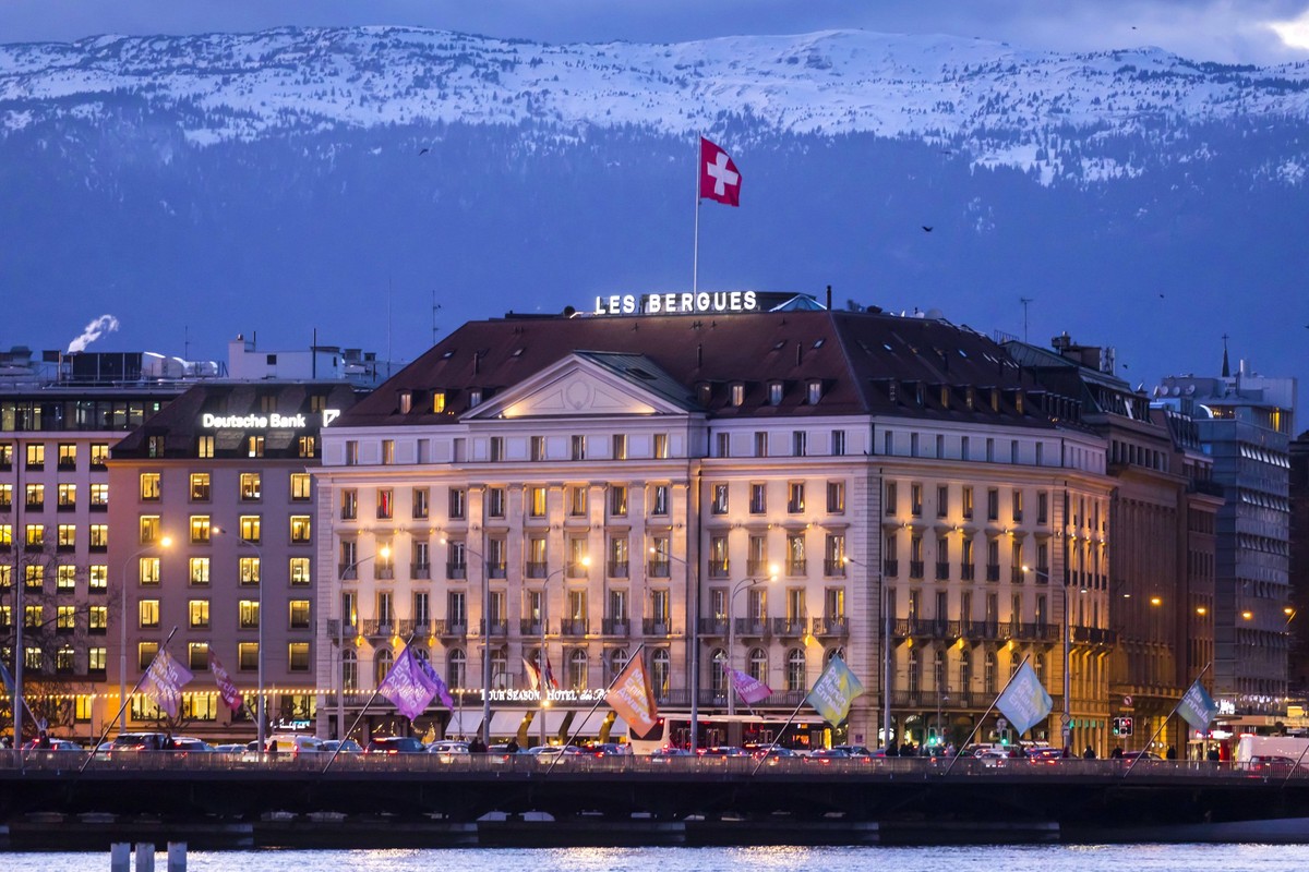 Geneva, Switzerland February 18, 2020 - End of day atmosphere by the lake in the city center of Geneva - View of luxury palace Four Seasons Hotel des Bergues Geneva at dusk GENEVE, SUISSE, ILLUSTRATIO ...