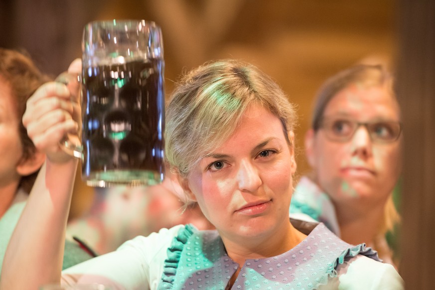 epa06994202 Katharina Schulze, leading candidate of The Greens party for the upcoming regional Bavaria state elections, toasts with a Mass, a one liter mug of beer, during the Gillamoos political morn ...