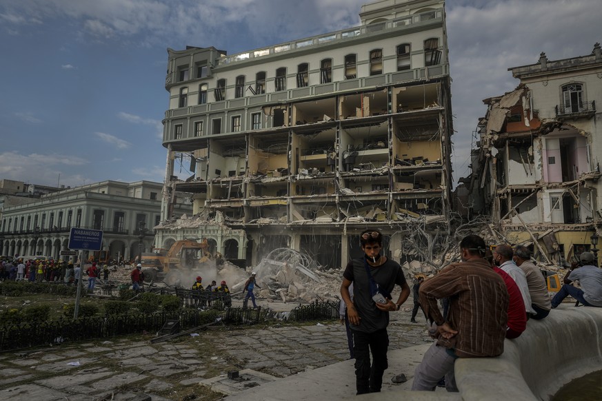 People watch the rescue effort at the site of a deadly explosion that destroyed the five-star Hotel Saratoga, in Havana, Cuba, Friday, May 6, 2022. A powerful explosion apparently caused by a natural  ...