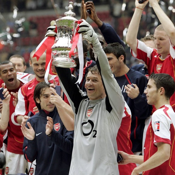 IMAGO / Paul Marriott

Torwart Jens Lehmann (Arsenal) präsentiert den FA Cup, hinter ihm feiert das Team - PUBLICATIONxNOTxINxUK Fußball Herren FA Cup 2004/2005, Finale, Endspiel, Arsenal FC London, E ...