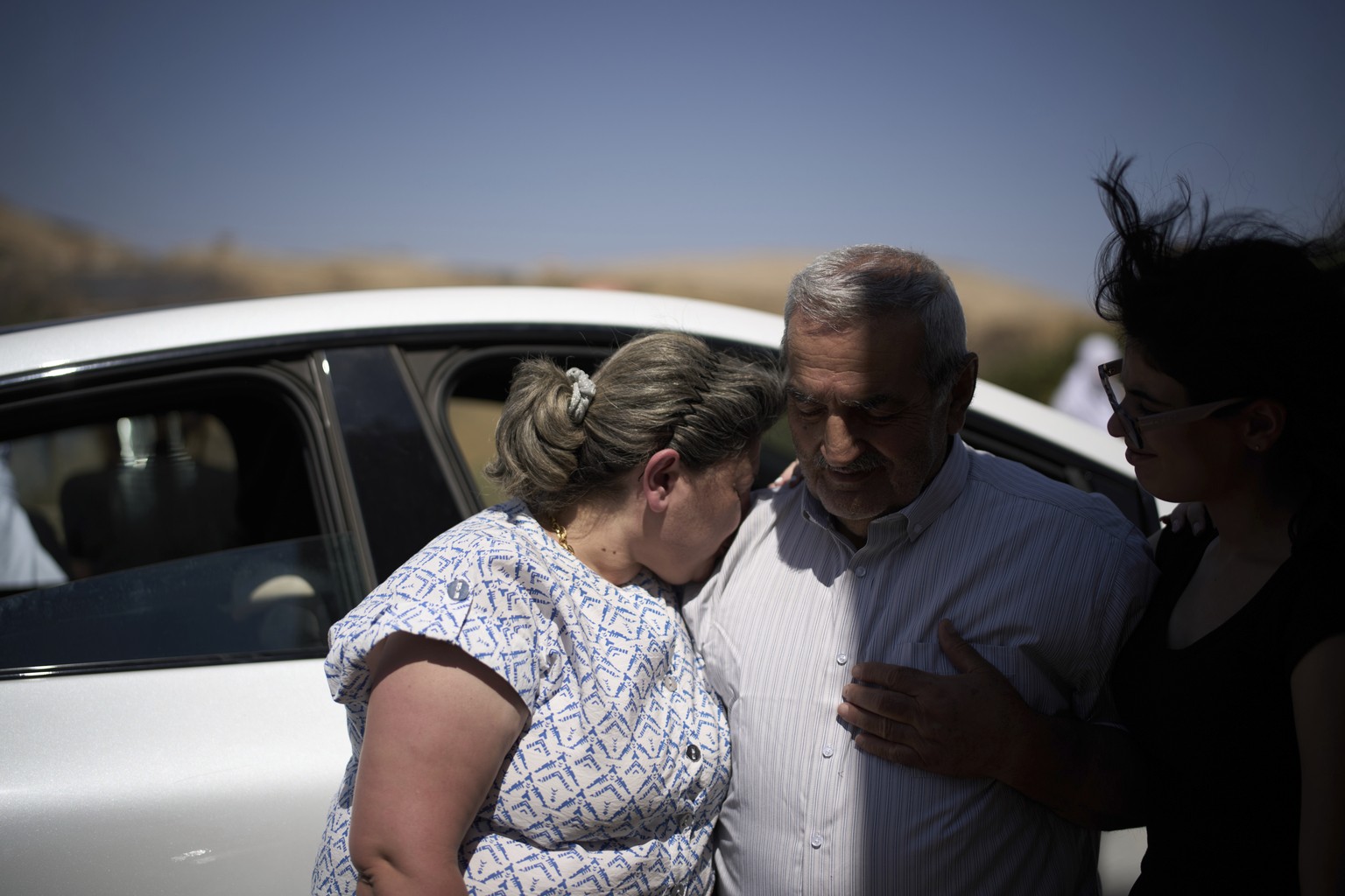 Syrian Druze, Fares Abu Zaid, 80, center, says goodbye to Druze relatives from Israel before crossing back into Syria at the Israeli-Syrian border, in the Israeli-controlled Golan Heights town of Majd ...
