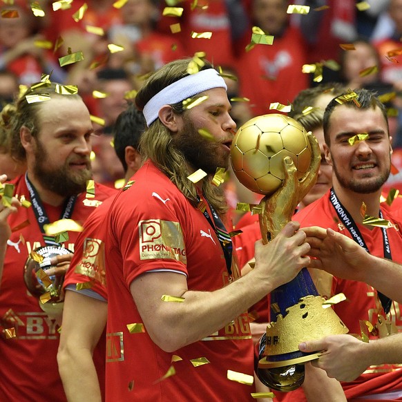 Denmark&#039;s keeper Niklas Landin, right, hands the trophy to Denmark&#039;s Mikkel Hansen after winning the Handball World Championship final match between Denmark and Norway in Herning, Denmark, S ...