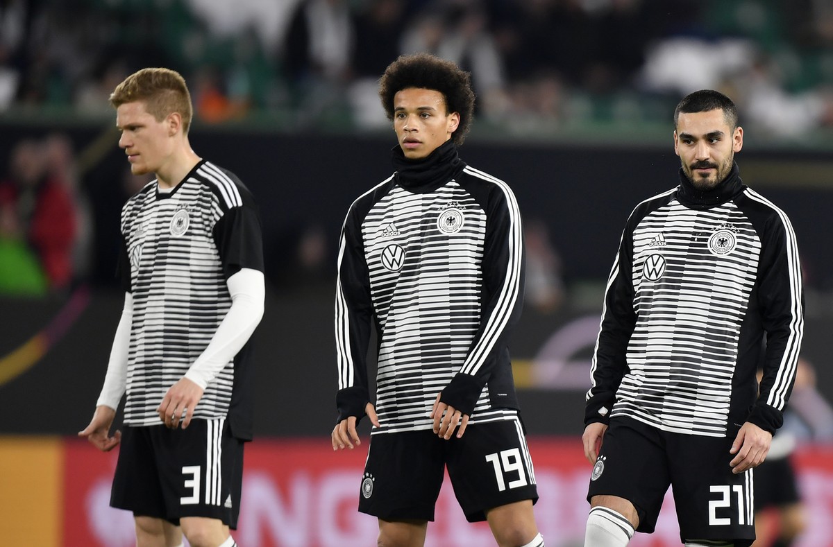 Germany's Marcel Halstenberg, left, Leroy Sane, center, and Ilkay Gundogan stand during warm up prior to a international friendly soccer match between Germany and Serbia at the Volkswagen Arena s ...