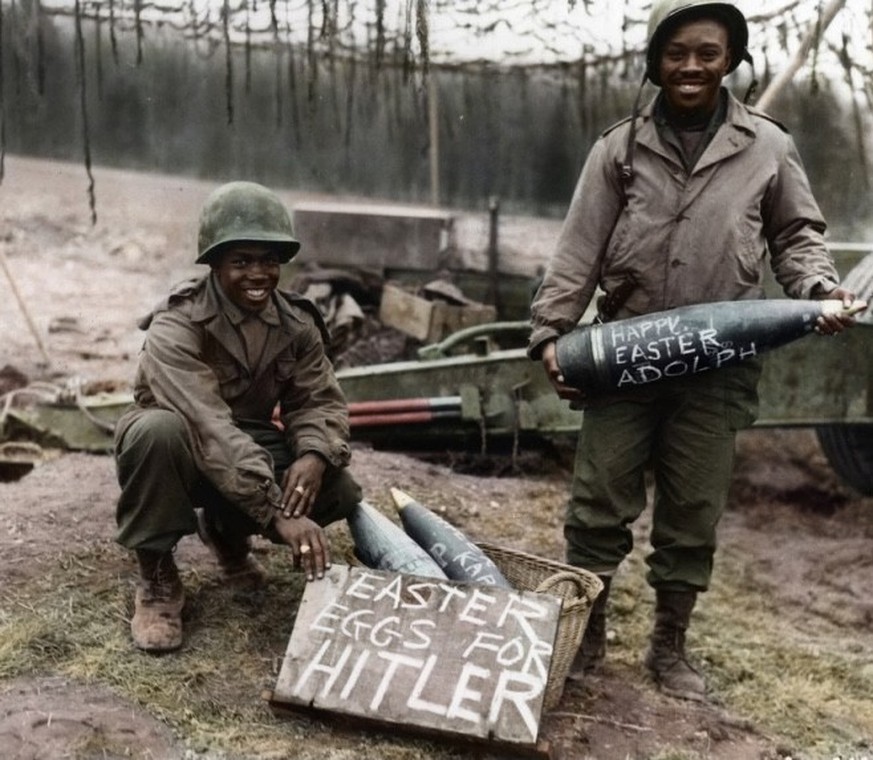 Easter morning finds Technician Fifth Grade (T/5) William E. Thomas and Private First Class (PFC) Joseph Jackson preparing a special easter egg basket for Hitler, March 1945. They smile while holding  ...