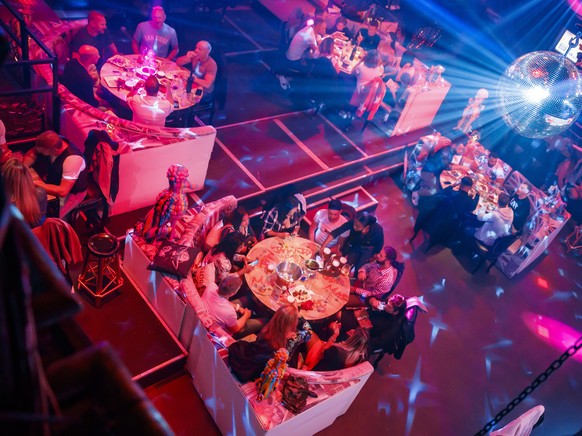epa08470737 People eat and drink at their table in a night club transformed into a restaurant as the current sanitary measures still discourage the usual clubbing experience, in Lausanne, Switzerland, ...
