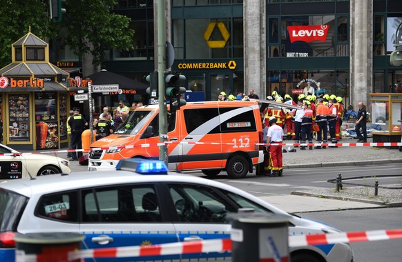 08.06.2022, Berlin: Polizei und Rettungsdienste sichern das Areal nach einem Zwischenfall. Ein Auto ist in der N