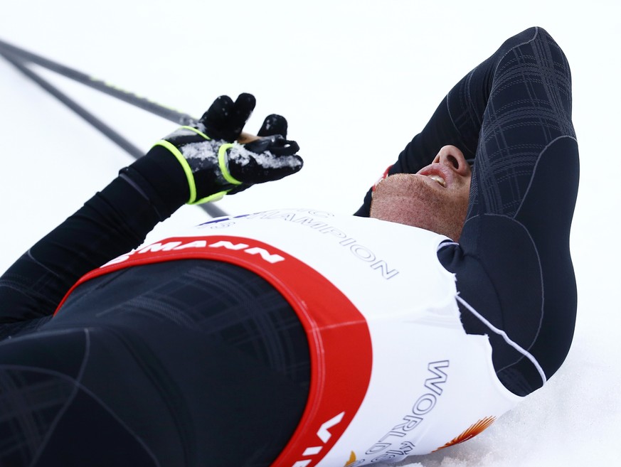 Dario Cologna liegt nach dem Schlusssprint völlig ausgepumpt im Zielraum.